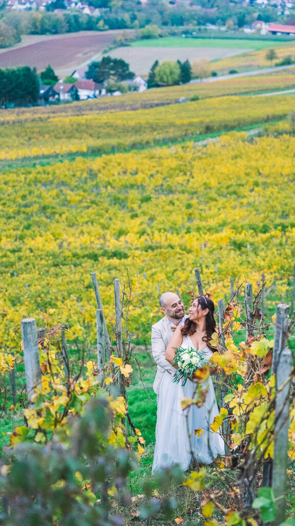 Hochzeitspaar inmitten der herbstlichen Weinberge