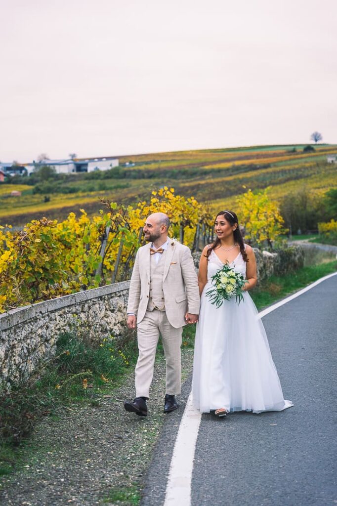 Hochzeitspaar läuft händchenhaltend auf der Straße